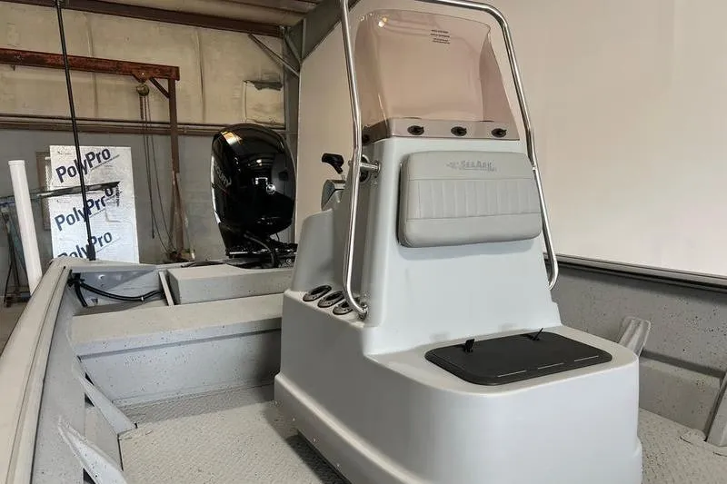 Slide: The Image of 2024 SeaArk 2272 MVT boat interior with console and motor in a warehouse setting. - 4