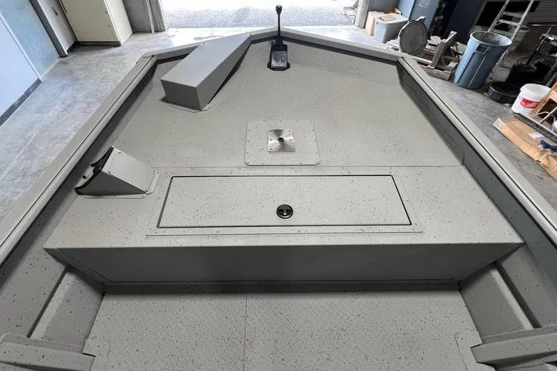 Slide: The Image of 2024 SeaArk 2272 MVT boat interior, featuring a spacious, speckled deck and storage compartments. - 6