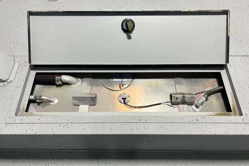 Slide: The Image of 2024 SeaArk 2272 MVT boat compartment with open hatch, showing internal components and wiring. - 7