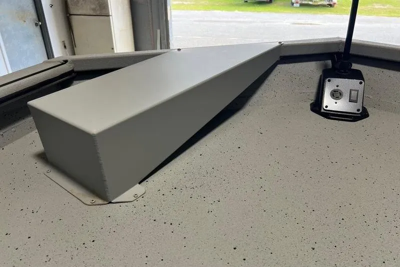 Slide: The Image of 2024 SeaArk 2272 MVT boat interior with a gray compartment and mounted device. - 8