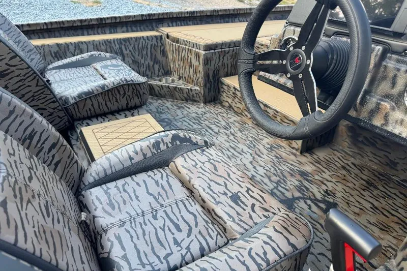 Slide: The Image of 2026 Xpress H20C Crappie boat interior with camo seats and steering wheel. - 2