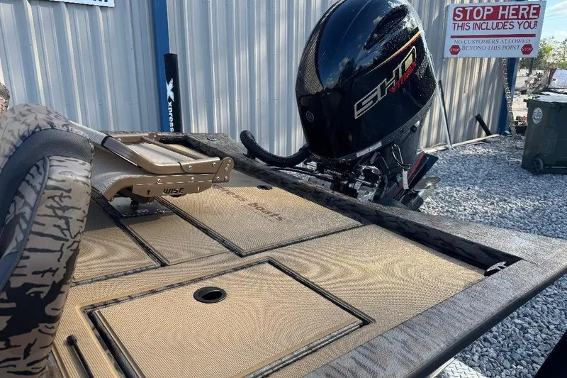 Slide: The Image of 2026 Xpress H20C Crappie boat with outboard motor, parked on gravel near a building. - 6