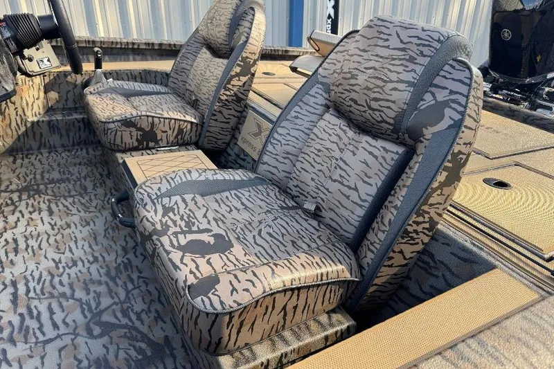 Slide: The Image of 2026 Xpress H20C Crappie boat interior with camo-patterned seats and flooring. - 7