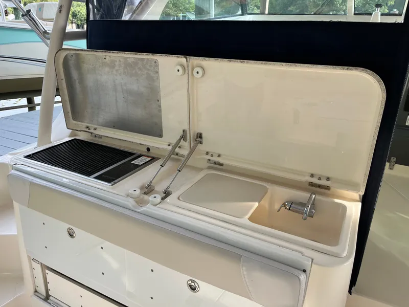 Slide: The Image of 2010 Pursuit OS 345 Offshore boat kitchen with sink and grill. - 13
