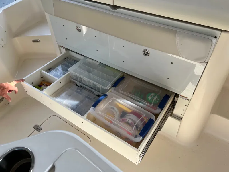 Slide: The Image of 2010 Pursuit OS 345 Offshore boat storage drawer with organized fishing gear and tackle boxes. - 15