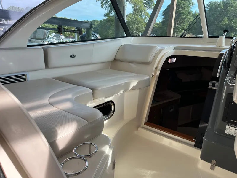 Slide: The Image of Interior of a 2010 Pursuit OS 345 Offshore boat with white seating and cup holders. - 17