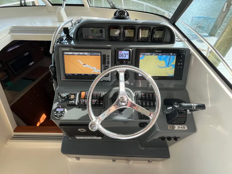 Slide: The Image of 2010 Pursuit OS 345 Offshore helm with navigation screens and controls. - 23