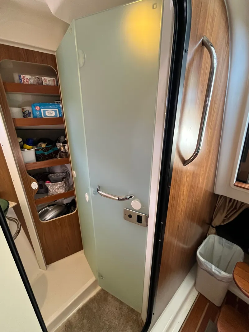 Slide: The Image of Interior of 2010 Pursuit OS 345 Offshore boat with frosted glass door and storage shelves. - 28