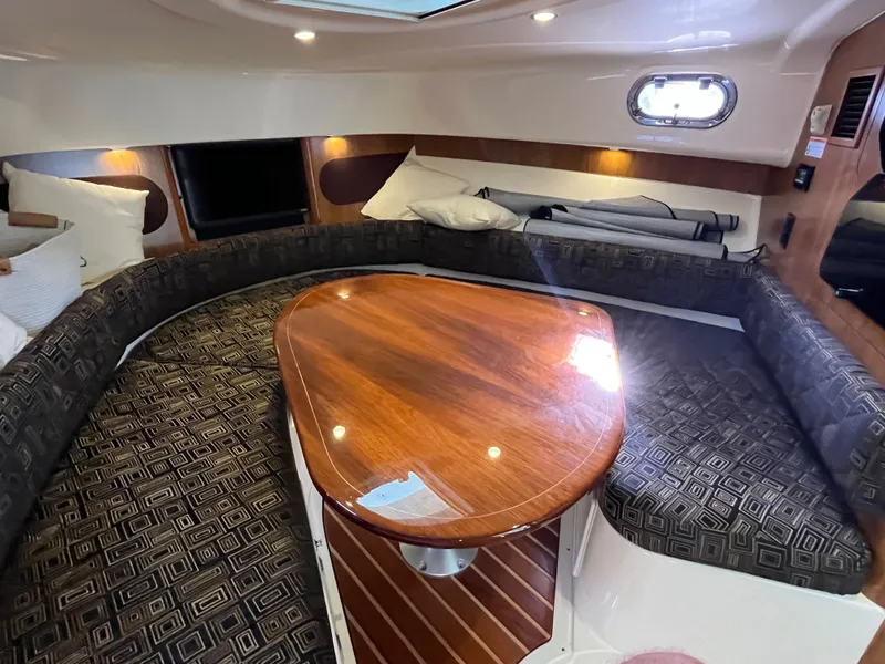 Slide: The Image of 2010 Pursuit OS 345 Offshore cabin with elegant wood table and cushioned seating. - 33