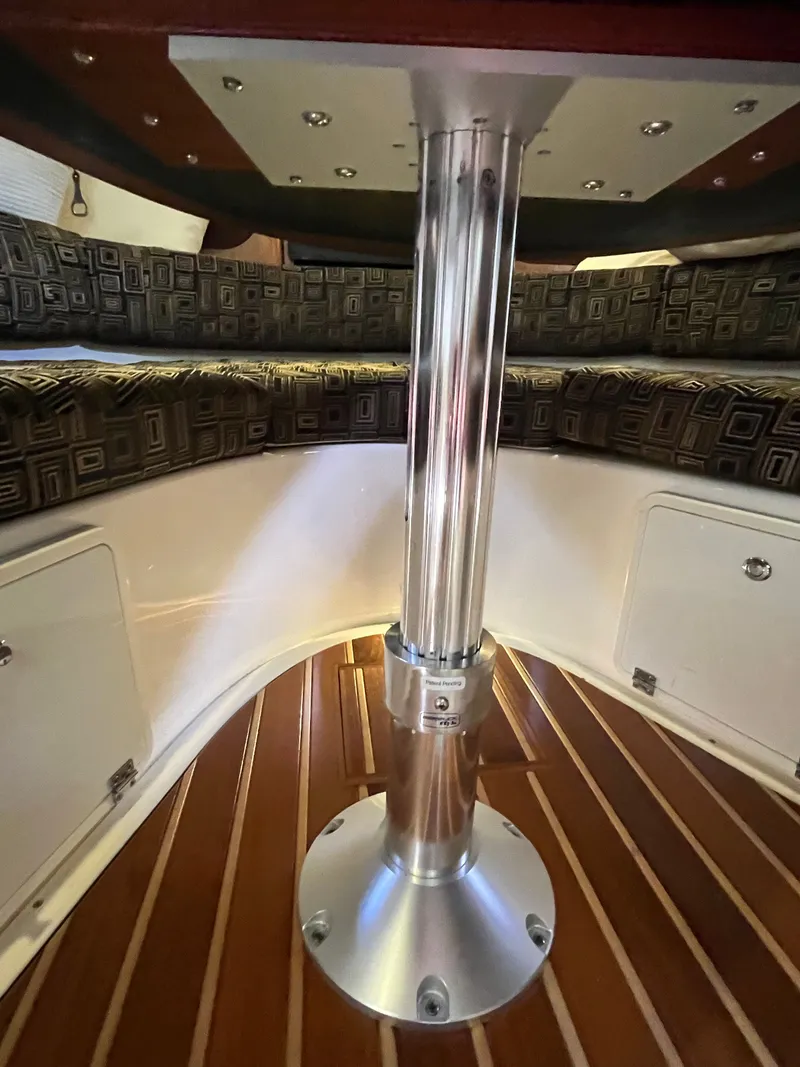 Slide: The Image of 2010 Pursuit OS 345 Offshore cabin interior with polished metal table support and cushioned seating. - 36
