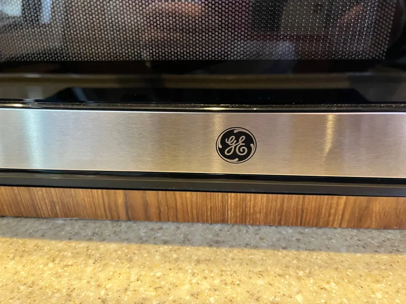 Slide: The Image of Stainless steel GE appliance with logo, set on a wooden and stone countertop. - 40