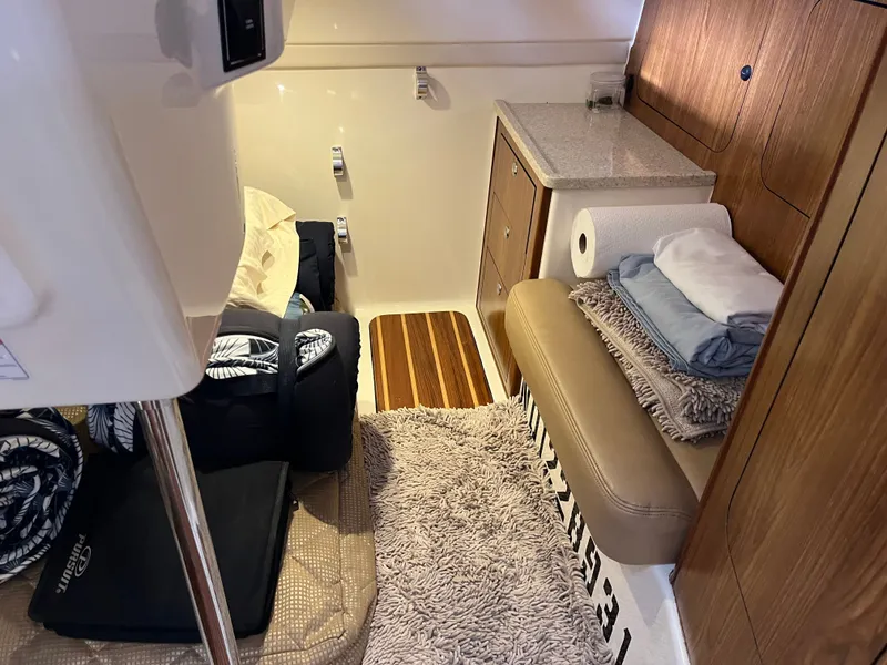 Slide: The Image of 2010 Pursuit OS 345 Offshore cabin interior with cozy seating and storage. - 41