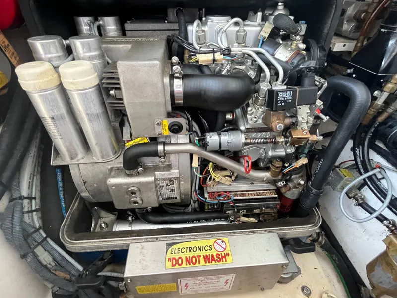Slide: The Image of Engine compartment of a 2010 Pursuit OS 345 Offshore boat, featuring complex machinery and wiring. - 46