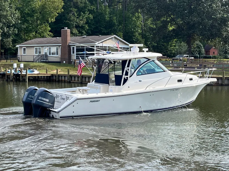 Slide: The Image of 2010 Pursuit OS 345 Offshore boat cruising near a lakeside house with Yamaha engines. - 49