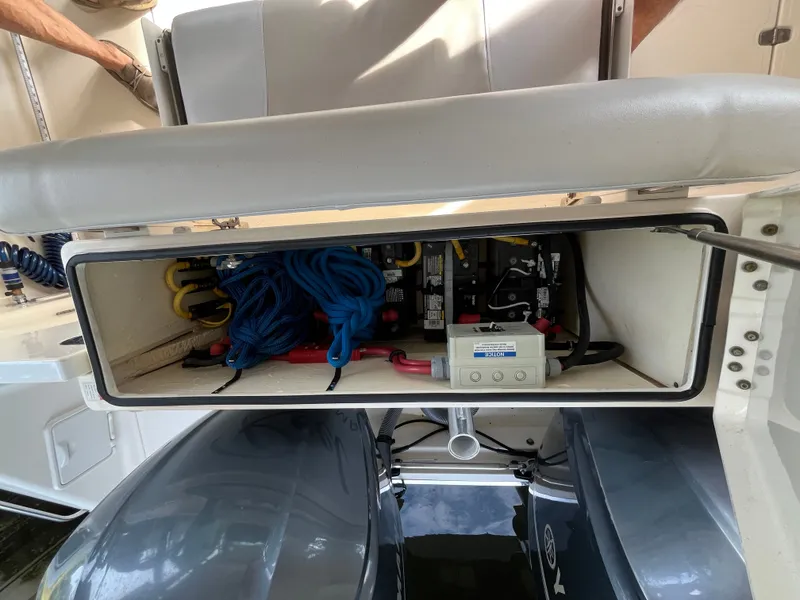 Slide: The Image of 2010 Pursuit OS 345 Offshore boat storage compartment with ropes and electrical components. - 7