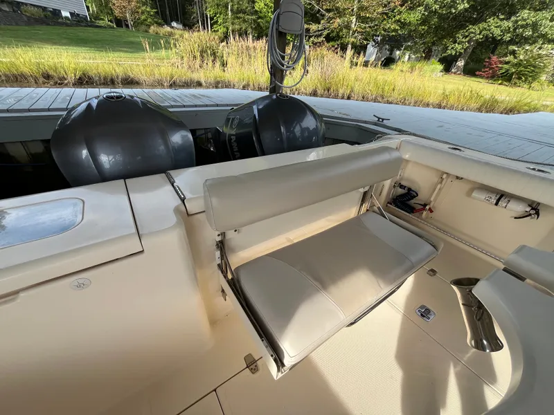 Slide: The Image of 2010 Pursuit OS 345 Offshore boat interior with seating and dual outboard motors. - 9