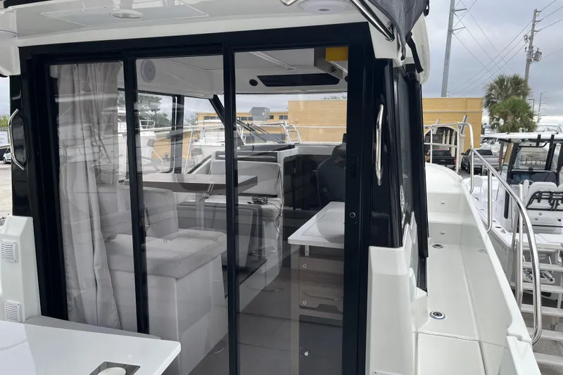 Slide: The Image of 2025 Jeanneau NC 895 Sport Series 2 boat interior with sliding glass doors and seating area. - 20