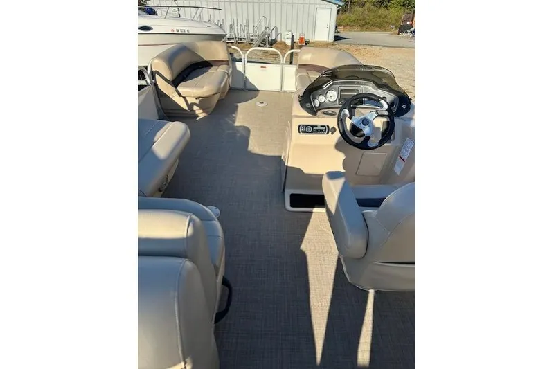 Slide: The Image of 2017 Sun Tracker Party Barge 22 DLX interior with beige seating and steering console. - 15