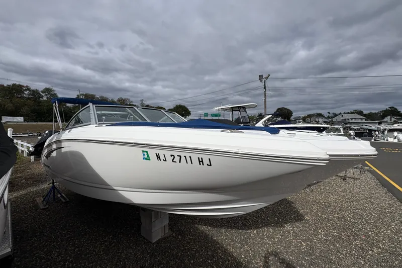 The Image of 2015 Chaparral 264 Sunesta boat with sleek design, docked outdoors under cloudy skies. - 0