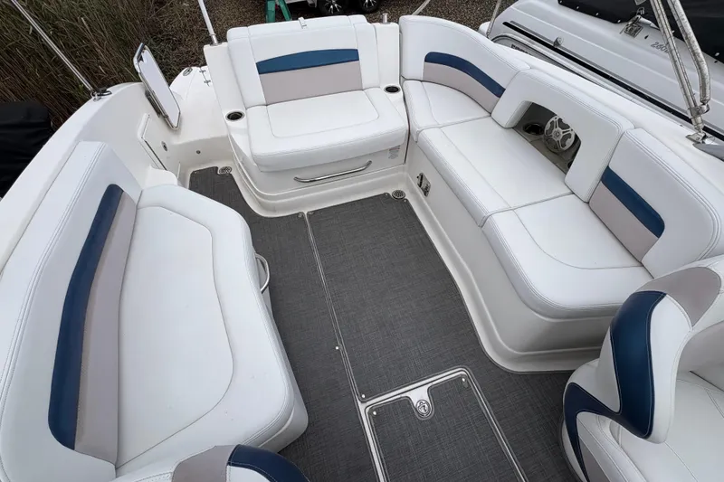 Slide: The Image of 2015 Chaparral 264 Sunesta boat interior with white and blue seating arrangement. - 9