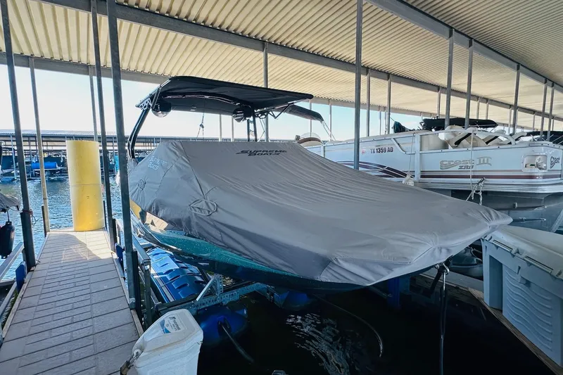 Slide: The Image of 2021 Supreme ZS232 boat covered and docked in a marina. - 10
