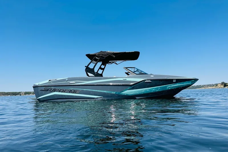 Slide: The Image of 2021 Supreme ZS232 boat on calm water under clear blue sky. - 3