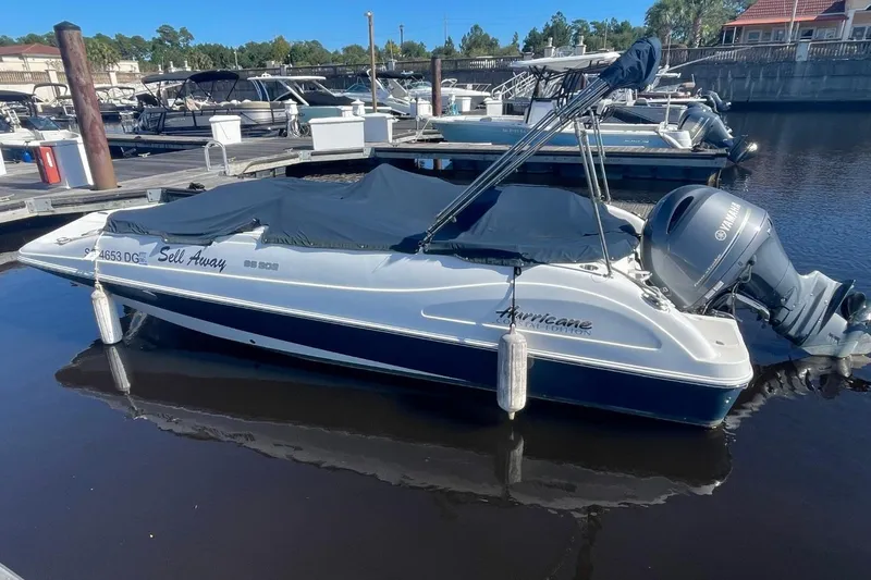 Slide: The Image of 2017 Hurricane SunDeck Sport 202 OB boat docked with cover, Yamaha outboard motor. - 2