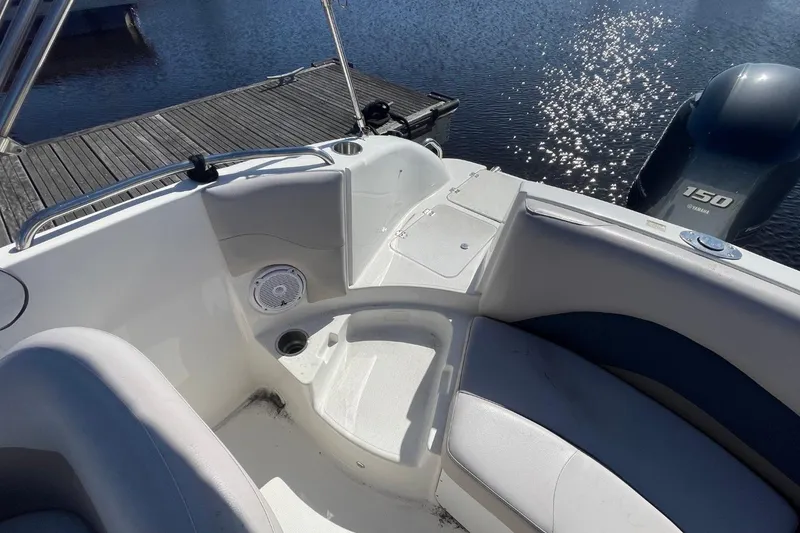 Slide: The Image of 2017 Hurricane SunDeck Sport 202 OB boat interior with Yamaha 150 engine by a dock. - 6
