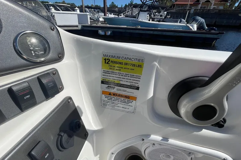 Slide: The Image of 2017 Hurricane SunDeck Sport 202 OB boat dashboard with capacity warning label. - 9