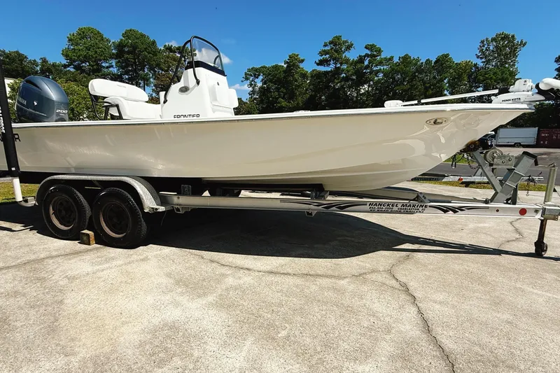 The Image of 2023 Frontier 2104 boat with Yamaha engine on calm water, surrounded by lush greenery. - 0