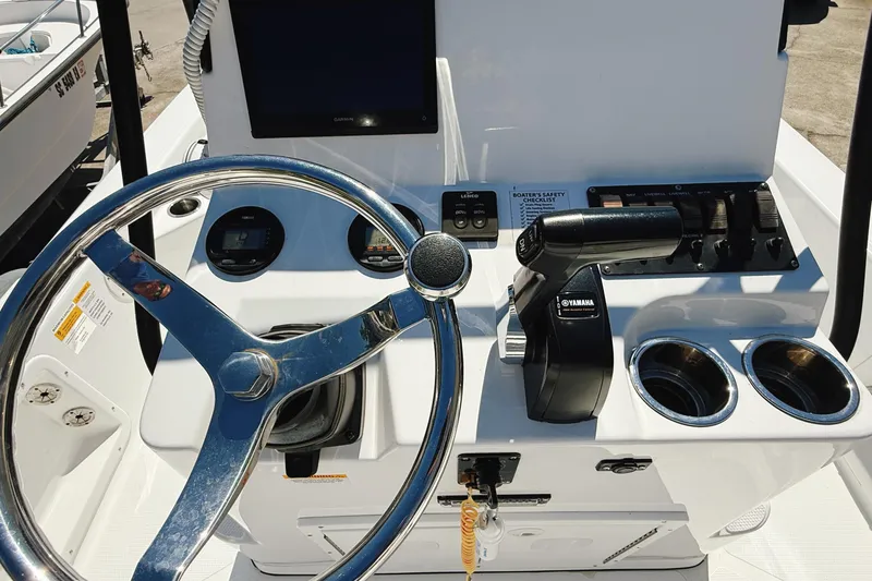 Slide: The Image of 2023 Frontier 2104 boat on trailer, parked outdoors, with Yamaha engine. - 12