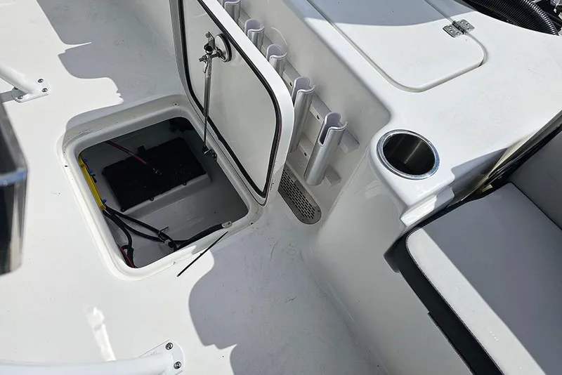 Slide: The Image of 2026 Sea Pro 210 Bay boat interior with open storage compartment and cup holder. - 14