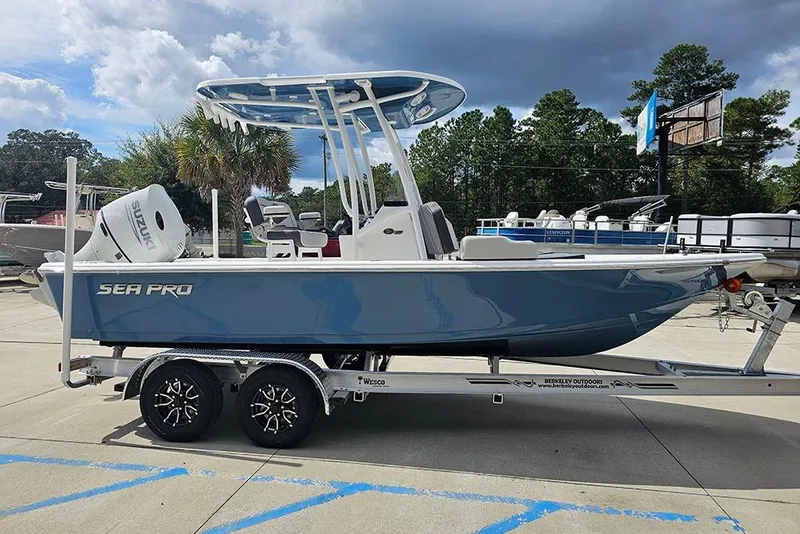 Slide: The Image of 2026 Sea Pro 210 Bay boat on trailer, blue hull, Suzuki outboard, outdoor setting. - 6