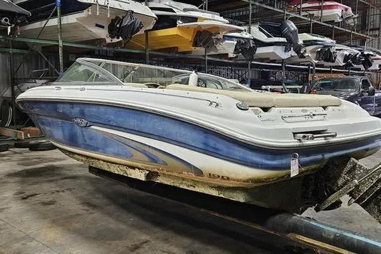 The Image of Sea Ray SRV 197 BR 2000 boat in storage, showing wear and blue hull design. - 1