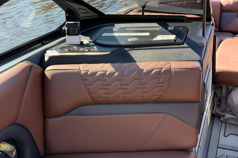 Slide: The Image of 2026 Centurion Ri230 boat interior with brown leather seating and cup holders. - 17