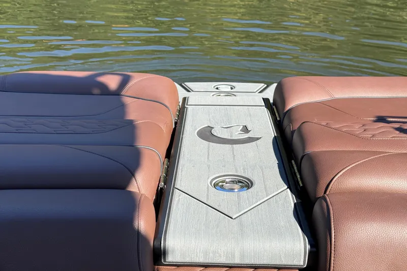 Slide: The Image of 2026 Centurion Ri230 boat with brown leather seats and sleek design on water. - 18