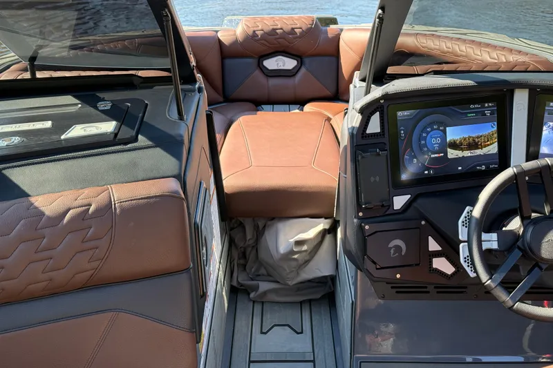 Slide: The Image of 2026 Centurion Ri230 boat interior with brown leather seats and advanced dashboard display. - 22