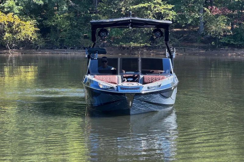 Slide: The Image of 2026 Centurion Ri230 boat on calm lake with forest backdrop. - 5