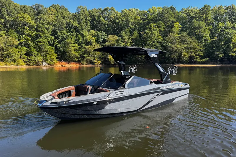 Slide: The Image of 2026 Centurion Ri230 boat on a serene lake with lush forest backdrop. - 9