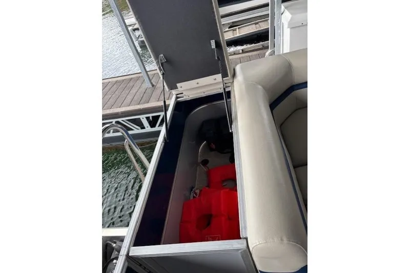 Slide: The Image of Open storage compartment on 2017 South Bay 222 RS boat with life jackets inside. - 22