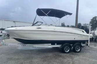 The Image of 2022 Bayliner VR6 Bowrider OB on trailer, featuring sleek design and canopy. - 0