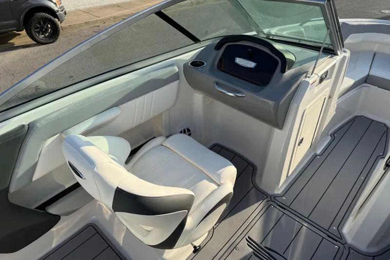 Slide: The Image of 2022 Chaparral 21 SSi boat interior with white seating and sleek dashboard design. - 10