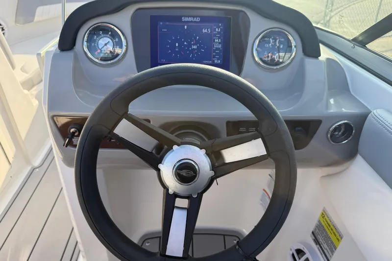 Slide: The Image of 2022 Chaparral 21 SSi boat dashboard with steering wheel and digital display. - 17