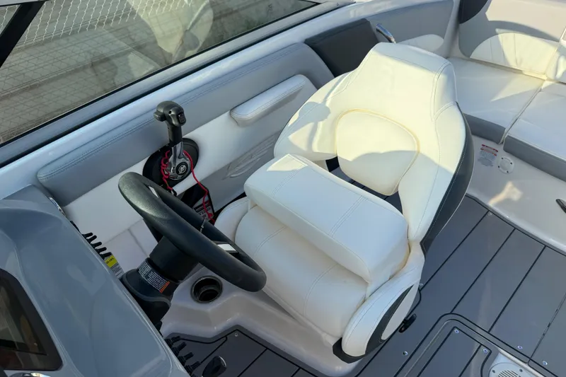 Slide: The Image of 2022 Chaparral 21 SSi boat interior with steering wheel and white captain's seat. - 22