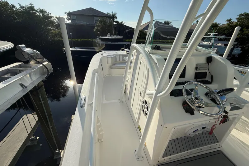 Slide: The Image of 2019 Twin Vee 26 Center Console boat docked, featuring steering wheel and control panel. - 10