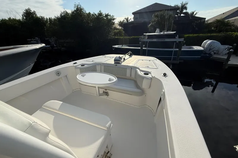 Slide: The Image of 2019 Twin Vee 26 Center Console boat with seating and table, docked near other boats. - 12