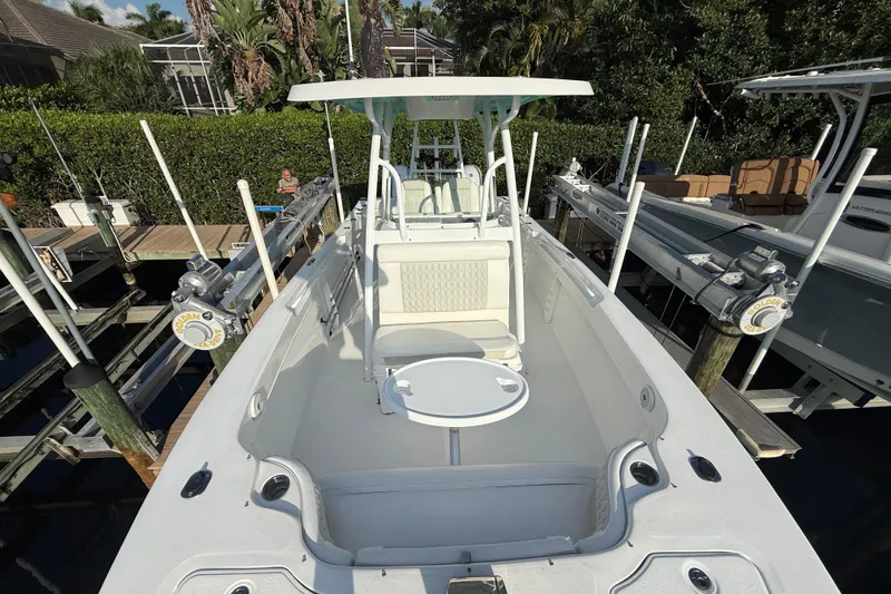 Slide: The Image of 2019 Twin Vee 26 Center Console boat docked, featuring spacious seating and fishing equipment. - 13
