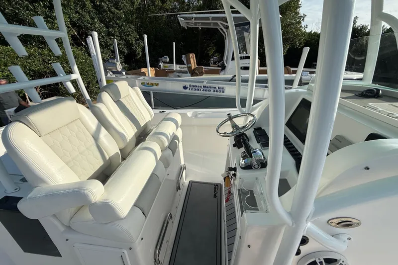 Slide: The Image of 2019 Twin Vee 26 Center Console boat interior with white seating and steering console. - 9