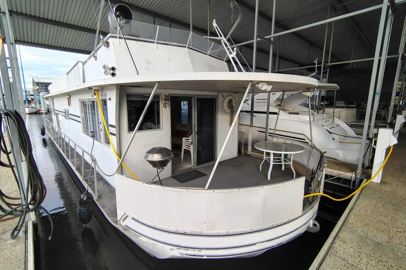 The Image of 1981 Lazy Days 50 houseboat docked, featuring outdoor seating and grill. - 0