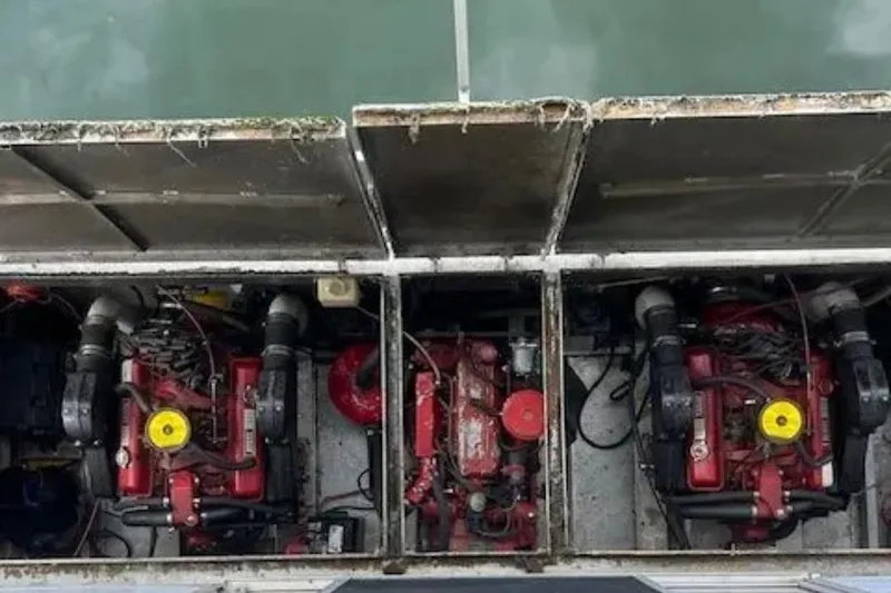 Slide: The Image of Engine compartment of a 1981 Lazy Days 50 boat, featuring dual red engines. - 18